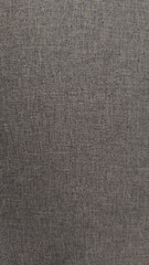 Close-up of a gray woven fabric texture. Detailed view of linen or canvas material with a heathered effect. Natural textile background for design, upholstery, and fashion concepts. Empty space.