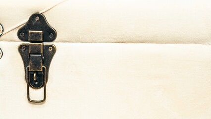 The intricately designed clasp of a vintage trunk is shown in a close-up shot.