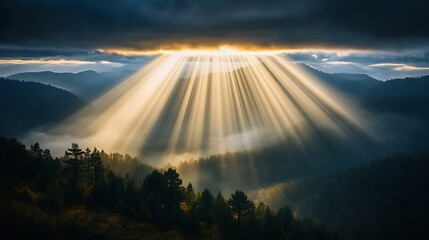Sunbeams piercing through a dark sky over a misty mountain range