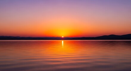 Fototapeta premium Sunrise over a calm lake reflecting the vibrant colors of the sky.