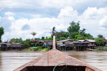 Colorful wooden fishing and transport boats moored on the muddy Mekong River in Laos 