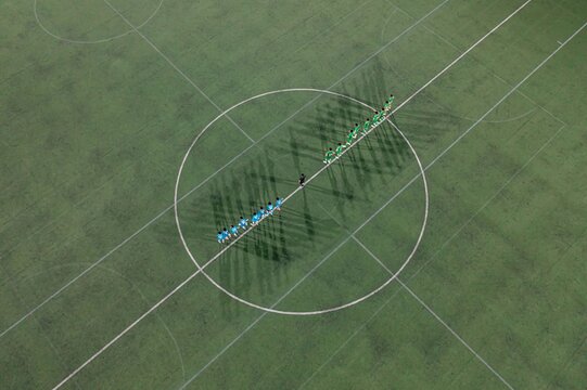 Aerial view of soccer teams lined up on the field.