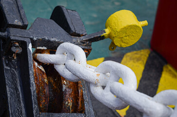 The anchor chain secured by a cable stopper - a mechanical device that holds the anchor chain when...