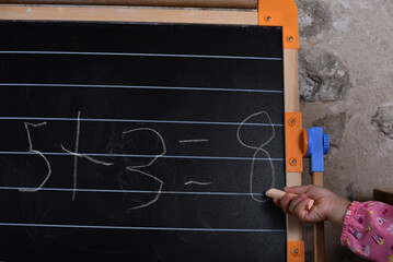 Little girl doing mathematical addition in primary school level.