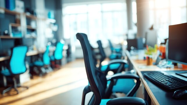 Empty office space with teal chairs and computers.