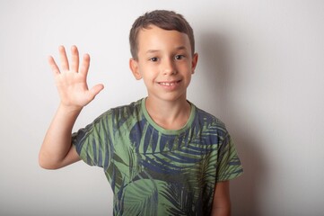 A little boy with an open fist on a white background. About 7 years. 