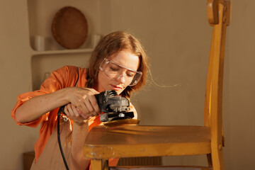 Woman Sanding Wooden Chair for Restoration at Home