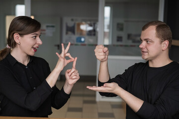 A man and a woman are talking in Russian sign language. 