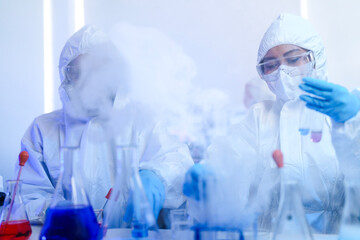 A team of scientists in hazmat suits works on a vaccine in a high-security biocontainment lab. Concept for pandemic response, virology, and medical research.