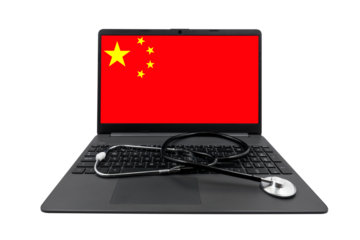 Laptop with China flag on screen and medical stethoscope on transparent background. China healthcare system concept