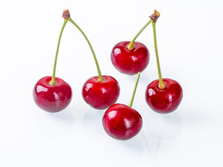 Vibrant ripe cherries placed on a white background captured in side view perspective