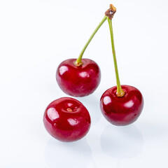 Fresh and juicy ripe cherries displayed on a white background side view