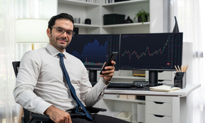 Profile of successful in smiling trader businessman looking at camera with holding phone two stock...