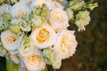 Elegant wedding bouquet of soft ivory and pastel peach roses with delicate green buds. Two gold wedding rings rest on the center rose, symbolizing love and commitment. Perfect for wedding invitations