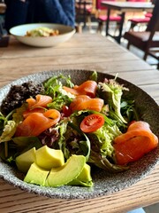 Healthy Salmon and Avocado Salad Served at Cozy Restaurant Table
