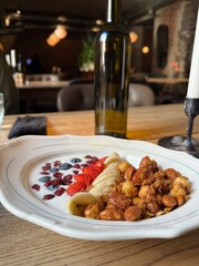 Healthy Yogurt Bowl with Granola, Banana and Berries in Cozy Restaurant Setting
