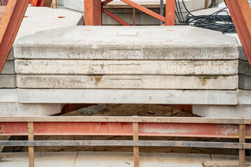 Heavy concrete construction counterweights stacked on industrial site for building machinery stabilization and structural support during large scale engineering projects