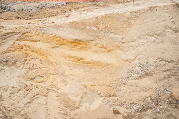 Natural textured construction site sand with yellow tones and excavation marks for building...