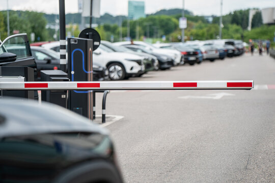Modern parking lot with automatic barrier gate and electric vehicle charging station in urban area providing secure access control for parked cars