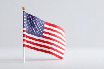 Obraz premium minimalist shot of single small american flag on plain white background