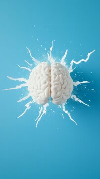 White anatomical model of human brain exploding with white paint splattering on blue background, representing stress, anger management, mental health, and creativity issues