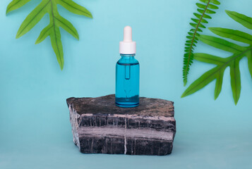 Frasco de ácido hialurónico azul sobre piedra con fondo tropical minimalista