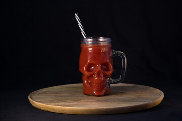 A skull-shaped mug filled with a blood-red drink
