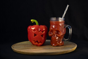 Jack o lantern bell pepper and a blood-red drink. Skull-shaped mug