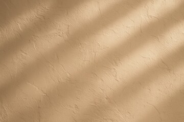 Obraz premium Elegant textured wall backdrop in warm beige tones with natural lighting for luxury product photography