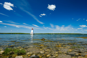The beautiful harbor and rocky beach at low tide and the Sandy Point Lighthouse on the southern shore of Nova Scotia
