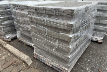 Paving stones neatly stacked and securely wrapped with stretch film on a pallet, ready for transport or storage. Ideal for construction, logistics, and building materials projects.