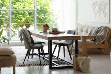 Wooden table, chairs, sofa and decor in dining room. Interior design