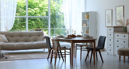 Beautiful table setting, chairs and decor in dining room. Interior design