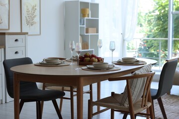 Beautiful table setting, chairs and decor in dining room. Interior design
