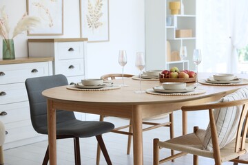 Beautiful table setting, chairs and decor in dining room. Interior design