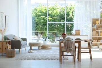 Beautiful table setting, chairs and decor in dining room. Interior design