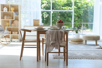 Beautiful table setting, chairs and decor in dining room. Interior design