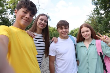 Group of teenagers taking selfie in park