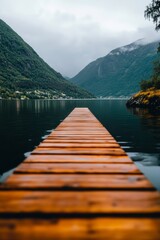 Fototapeta premium Wooden Dock Extending Over Calm Lake Surrounded by Mountains Under Cloudy Sky.