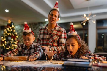 Latino family having fun baking Christmas cookies in the kitchen