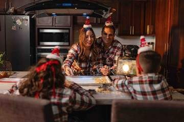 Parents baking Christmas cookies with children in cozy holiday kitchen