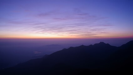 Serene Sunrise Over Misty Mountains: Purple and Orange Hues, Silhouette Landscape Photography