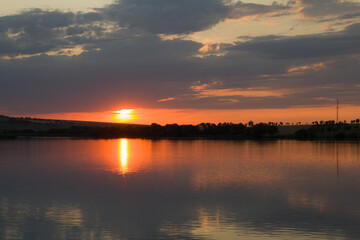 Fototapeta premium A sunset over a body of water