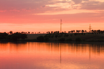 Fototapeta premium A body of water with trees and a tower in the background