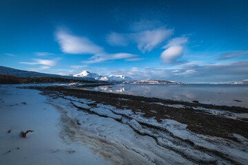 Serene Winter Shoreline with Distant Mountains