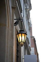 Lantern glows above heritage. Stone tells old stories. Window reflects memory. Every element here resists time and insists on presence.

