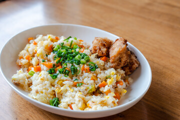 Fried Rice with Fried Chicken on White Plate / 白い皿に盛り付けたチャーハンと唐揚げの昼食
