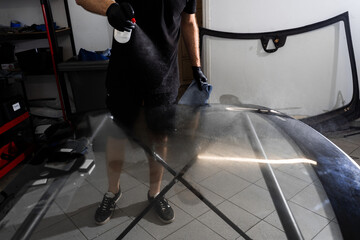 Windshield Surface Cleaning Before Installation. Spraying and wiping windshield before...