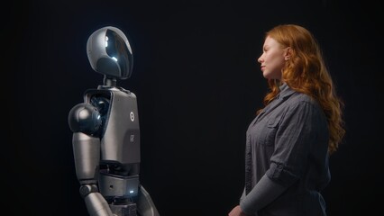 Futuristic Human-Machine Concept: Visualization of Young Woman Speaking with High-Tech Humanoid...