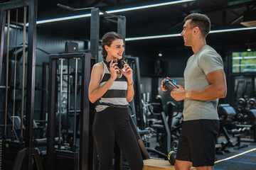 Personal trainer discuss with his female client about goals at gym